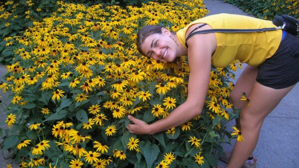 Girl posing with yellow rudbeckia flowers